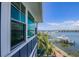 Exterior elevation showing a blue home with windows overlooking the water, dock and boats on a sunny day at 201 Bay N Dr, Bradenton Beach, FL 34217