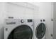 Bright laundry room with a new LG front-load washer and dryer set, and white shelving for storage at 201 Bay N Dr, Bradenton Beach, FL 34217