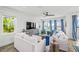 Bright living room featuring white furniture, wood floors, a ceiling fan, and water views at 201 Bay N Dr, Bradenton Beach, FL 34217