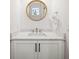 Elegant powder room featuring a round gold mirror and white quartz countertop at 201 Bay N Dr, Bradenton Beach, FL 34217