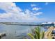 Scenic waterfront view featuring a long pier, calm water, and clear blue sky with fluffy white clouds at 201 Bay N Dr, Bradenton Beach, FL 34217