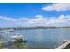 Scenic waterfront view with boats docked and a bridge in the distance under a bright, cloudy sky at 201 Bay N Dr, Bradenton Beach, FL 34217