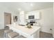Bright kitchen boasts white cabinets, stainless steel appliances, and a central island with bar seating at 20276 Emerald Ave, Port Charlotte, FL 33952