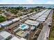 Aerial view of a charming community with a sparkling pool, shuffleboard court, and picturesque coastal views at 2107 Palma Sola Blvd # 95, Bradenton, FL 34209