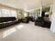 Spacious living room featuring neutral carpet, large windows, and comfortable leather furniture at 2107 Palma Sola Blvd # 95, Bradenton, FL 34209