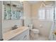 Cozy bathroom with white tiled walls, toilet, vanity, and shuttered window at 214 49Th W St, Bradenton, FL 34209