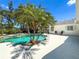 Backyard pool area with mature palm trees, deck, and lounge chairs for relaxing outdoors at 214 49Th W St, Bradenton, FL 34209