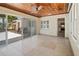 Open-concept sunroom featuring a wood ceiling, tiled floors, and a view into the kitchen at 214 49Th W St, Bradenton, FL 34209
