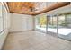 Spacious sunroom with wood ceiling, tile floor, and sliding glass doors to the backyard pool at 214 49Th W St, Bradenton, FL 34209