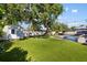 Expansive backyard with artificial turf, shed, and lush greenery is ideal for outdoor activities at 2202 Alpine Ave, Sarasota, FL 34239
