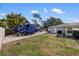 Spacious backyard featuring a boat on a trailer, green lawn, and access to the property's outbuildings at 2202 Alpine Ave, Sarasota, FL 34239