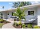 Exterior of home featuring a cozy outdoor seating area, hammock, and well-maintained landscaping at 2202 Alpine Ave, Sarasota, FL 34239