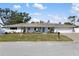 Charming single-story home with a blue front door, well-maintained lawn, and attached two-car garage at 2202 Alpine Ave, Sarasota, FL 34239