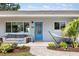 Charming front porch with outdoor seating, a blue door, and well-maintained landscaping creating a welcoming entrance at 2202 Alpine Ave, Sarasota, FL 34239