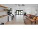 Open-concept living room with a plush sofa, neutral tile floors, and sliding glass doors to outdoor area at 2202 Alpine Ave, Sarasota, FL 34239