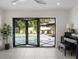 Elegant living room features folding doors to the pool, a piano, and tiled flooring at 2202 Alpine Ave, Sarasota, FL 34239