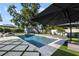 Luxurious backyard pool featuring a jacuzzi, patio furniture under umbrellas, and artificial turf at 2202 Alpine Ave, Sarasota, FL 34239