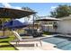 Backyard pool area with lounge chairs, a patio set, and a covered boat, perfect for outdoor relaxation at 2202 Alpine Ave, Sarasota, FL 34239