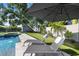 Serene backyard pool featuring lounge chairs, mature shade trees, and a putting green for leisure at 2202 Alpine Ave, Sarasota, FL 34239
