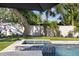 Relaxing pool and spa combination features a travertine patio and well-manicured lawn at 2202 Alpine Ave, Sarasota, FL 34239