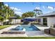 A luxury pool and integrated hot tub with an outdoor seating area surrounded by lush landscaping offers a private retreat at 2202 Alpine Ave, Sarasota, FL 34239