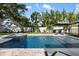 Backyard pool area with a jacuzzi, lounge chairs, mature trees, and manicured landscaping at 2202 Alpine Ave, Sarasota, FL 34239