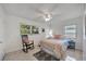 Bright bedroom features a rocking chair, ceiling fan, and natural light from the windows at 2307 Valencia Dr, Sarasota, FL 34239
