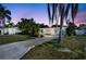 Charming single-story home with lush landscaping, a long driveway, and vibrant blue doors at 2307 Valencia Dr, Sarasota, FL 34239