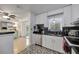 Kitchen featuring a stainless-steel sink, modern faucet, and white cabinetry with black countertops at 2307 Valencia Dr, Sarasota, FL 34239