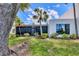 Exterior shot of a well-maintained home with a sunroom and lush lawn, surrounded by palm trees at 308 Timber Lake Dr, Bradenton, FL 34210