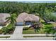 An aerial shot showcases a well-maintained home with palm trees and surrounding greenery at 3108 River Woods Dr, Parrish, FL 34219