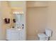 Bright bathroom with a toilet, vanity, and mirror with lighting at 3108 River Woods Dr, Parrish, FL 34219