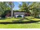 Landscaped entrance sign to River Woods community with manicured lawn and colorful plants at 3108 River Woods Dr, Parrish, FL 34219