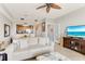 Bright living room featuring neutral tones, tile flooring, an open floor plan with ceiling fan and access to the staircase at 3248 Mangrove Point Dr, Ruskin, FL 33570