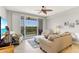 Comfortable living room with a ceiling fan, tile floors, access to a balcony, and serene views at 3248 Mangrove Point Dr, Ruskin, FL 33570