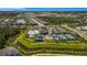 Aerial view of community amenities including a pool, clubhouse, tennis courts, playground, and parking area amidst lush landscaping at 3375 Juniper Springs St, Wesley Chapel, FL 33543