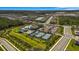Aerial view of community amenities including pool, tennis courts, and playground with homes and green spaces throughout the community at 3375 Juniper Springs St, Wesley Chapel, FL 33543