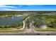 An aerial view of the neighborhood with a lake, fountain, and lush greenery at the gated community entrance at 3375 Juniper Springs St, Wesley Chapel, FL 33543