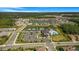Aerial view of a community with a pool, tennis courts, clubhouse, playgrounds, homes and a scenic lake at 3375 Juniper Springs St, Wesley Chapel, FL 33543