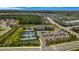 Aerial view showcasing community amenities including tennis courts, a pool, and clubhouse surrounded by lush greenery and residential areas at 3375 Juniper Springs St, Wesley Chapel, FL 33543