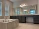 Luxurious primary bathroom featuring a soaking tub, dual vanities, and contemporary fixtures for a spa-like experience at 3375 Juniper Springs St, Wesley Chapel, FL 33543