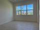 Neutral bedroom featuring a large window with views of the community and natural light at 3375 Juniper Springs St, Wesley Chapel, FL 33543