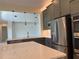 Contemporary kitchen with stainless steel appliances, gray cabinets, and island with white counter top at 3375 Juniper Springs St, Wesley Chapel, FL 33543