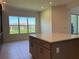 Bright kitchen featuring a central island with seating and a view through a large window at 3375 Juniper Springs St, Wesley Chapel, FL 33543
