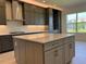 Stylish kitchen with dark gray cabinets, a large central island, and stainless steel appliances at 3375 Juniper Springs St, Wesley Chapel, FL 33543