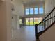 Bright living room with soaring ceilings, a staircase and backyard views through large windows at 3375 Juniper Springs St, Wesley Chapel, FL 33543