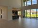 Open concept living room with views of the kitchen and backyard through large windows and sliding glass doors at 3375 Juniper Springs St, Wesley Chapel, FL 33543