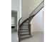 Elegant curved staircase with a decorative iron railing and carpeted steps at 3375 Juniper Springs St, Wesley Chapel, FL 33543