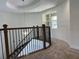 Carpeted staircase with wrought iron spindles and wooden handrail leading to a bright, open landing at 3375 Juniper Springs St, Wesley Chapel, FL 33543