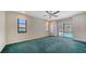 Bright main bedroom with green carpet featuring a sliding glass door to the screened-in patio and pool at 3572 Ferndell, Sarasota, FL 34235